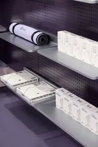 Shelves displaying fitness products in a minimalist retail environment.