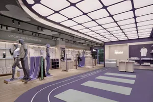 A minimalist retail store with wooden floors, glass display cases, and metallic accents.