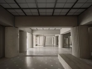 A modern public interior featuring concrete columns and a patterned floor.