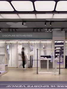 現代運動用品零售店，採用金屬牆面與展示架陳列運動服飾。