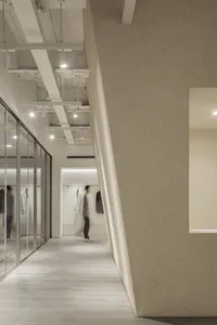 A minimalist retail storefront featuring concrete and glass materials.