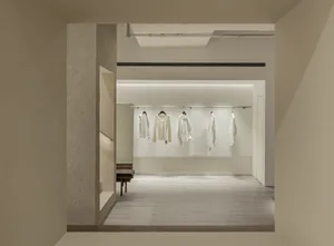 Minimalist retail storefront showcasing white clothing on a minimalist concept.