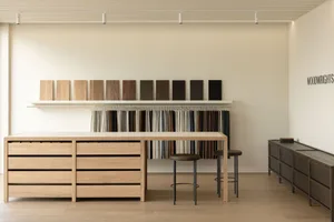A minimalist showroom showcasing various wood finishes and materials.