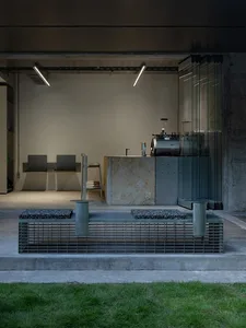 A sleek, modern industrial coffee shop featuring a marble counter and concrete columns.