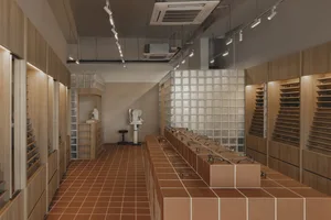 Modern interior of an optical shop with wooden finishes and display shelves showcasing glasses.