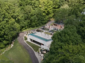 A modern residential exterior with concrete walls and a glass roof.