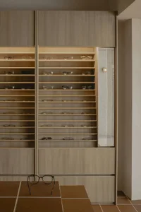 Modern retail shop with a wooden interior displaying various eyeglasses.