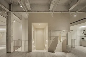現代零售店採極簡設計，混凝土牆面與地板，以及服裝展示架。