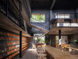 An industrial-style library with concrete walls and wooden furniture.