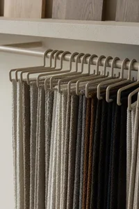 Towel hooks hanging on a product display shelf.