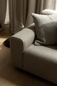 A textured grey cushion on a soft, comfortable sofa in a living room setting.