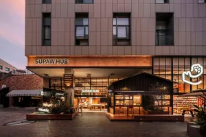 Supaw Hub storefront with brick facade and illuminated signage.