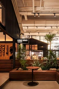 Industrial-themed restaurant event space featuring wood accents, concrete flooring, and metal accents.