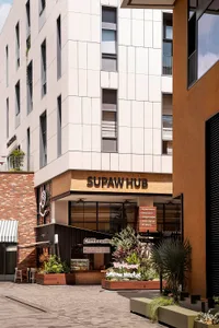 Modern commercial space with industrial design elements, featuring brick walls, concrete flooring, and lush green planters.