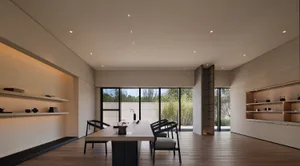 Modern dining room featuring a wooden table and black chairs.