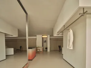 Modern, minimalist design of a clothing store featuring metallic, glass, and wooden elements.
