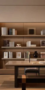 A modern home library with wooden shelves and stone accents.