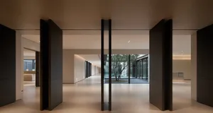 A modern office space featuring glass walls and wooden columns, creating a sleek and contemporary environment.