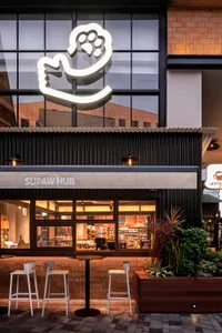 Modern retail storefront with brick and concrete materials and a paw print logo.