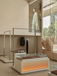 Modern retail clothing boutique with glass display cases featuring minimalist clothing designs.