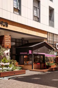 An urban retail storefront featuring wooden awnings, brick walls, and metal accents.