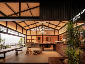 Brutalist event space with wooden elements and two dogs laying on the floor.