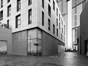 Modern building exterior with concrete facade and street view in black and white.
