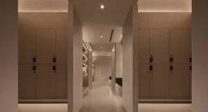 Modern commercial locker room with wooden lockers and white flooring.