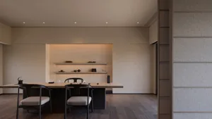 A modern dining room with wooden furniture and upholstered chairs.
