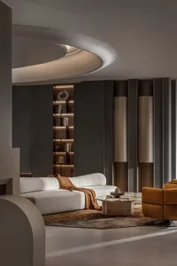 Modern living room with concrete walls, leather furniture, and metal accents.