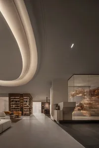 A modern lobby with concrete walls and floors, featuring curved ceiling lights and a glass wall with textured glass.