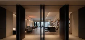 Modern office space with dark wood furnishings, featuring a dark wood desk and chairs, and a large window allowing natural li