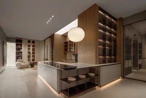 Modern residential kitchen featuring a marble countertop and wooden cabinets.