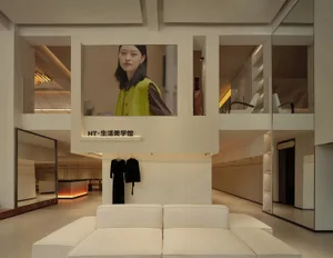 現代零售店內部，擺放白色沙發、懸掛黑色洋裝，並有大型螢幕播放人物畫面。