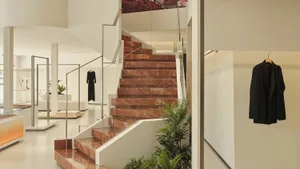 A modern retail space featuring a marble staircase with glass railings.