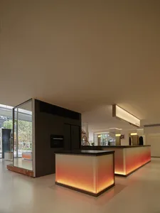 A modern retail space with illuminated glass walls and a central island counter.