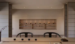 A serene tea room with a display of various teapots on a wooden shelf.