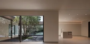 A minimalist interior design featuring a modern entry space with concrete and glass elements.