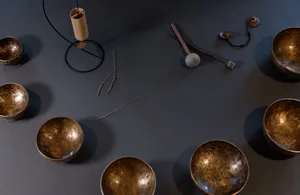 A display of metal bowls arranged on a dark surface with additional decorative objects and tools.
