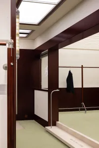 A clothing store with dark wood panels and a green floor.