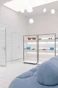 A minimalist retail space featuring metal, glass, and fabric elements.