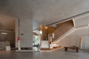 A modern interior space with concrete walls, a concrete staircase, and minimalist design.