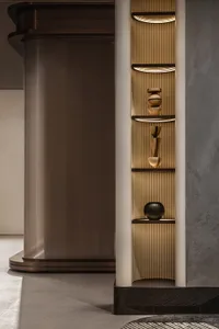 A modern interior space featuring a decorative display of wooden objects illuminated by indirect lighting.