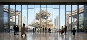 People walking in a modern interior featuring glass, concrete, steel, and plant features.