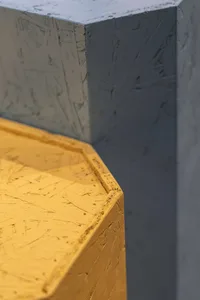 Close-up of a modern interior design featuring yellow-painted concrete walls.