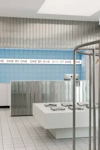 A clean, modern retail checkout counter featuring metallic materials and a minimalist design.