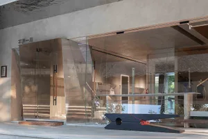 A modern retail storefront with glass walls and concrete elements.