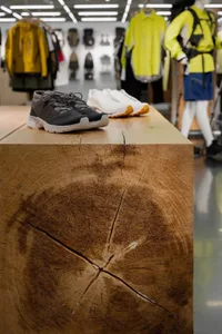 A wooden table displaying athletic shoes in a retail environment.