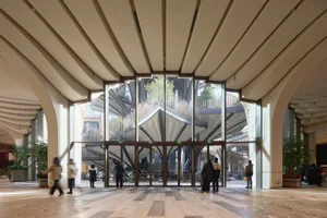 Modern lobby with glass walls and arched columns.