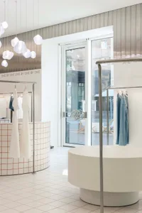 Modern retail store with minimalist design featuring concrete and glass materials.